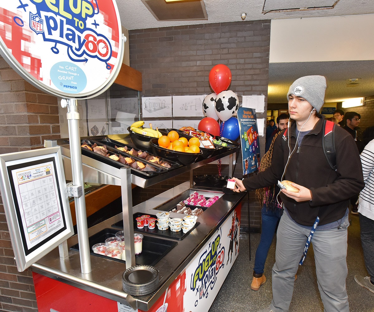 Young man grabbing a milk carton from a school dairy cart