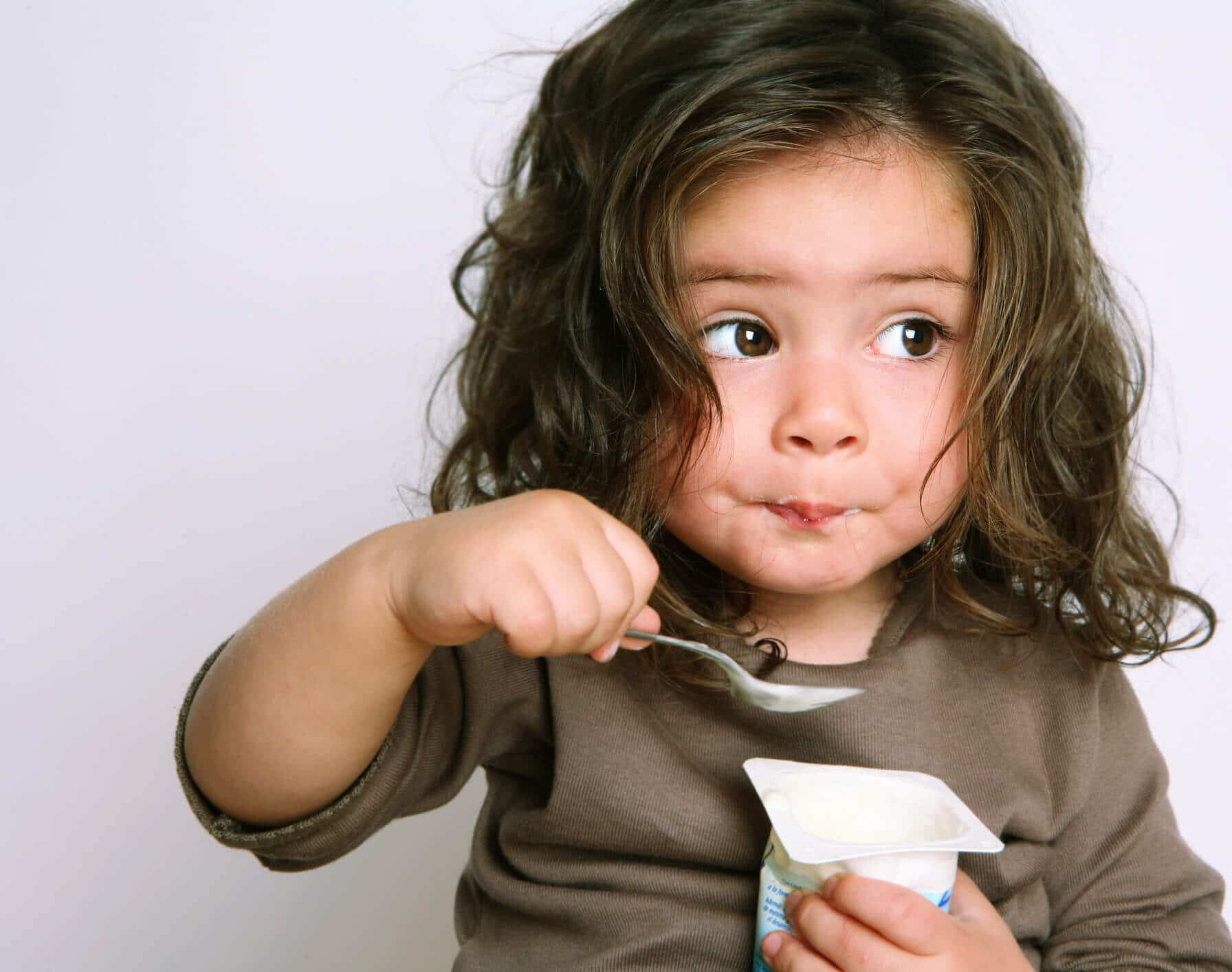 Little girl eating yogurt