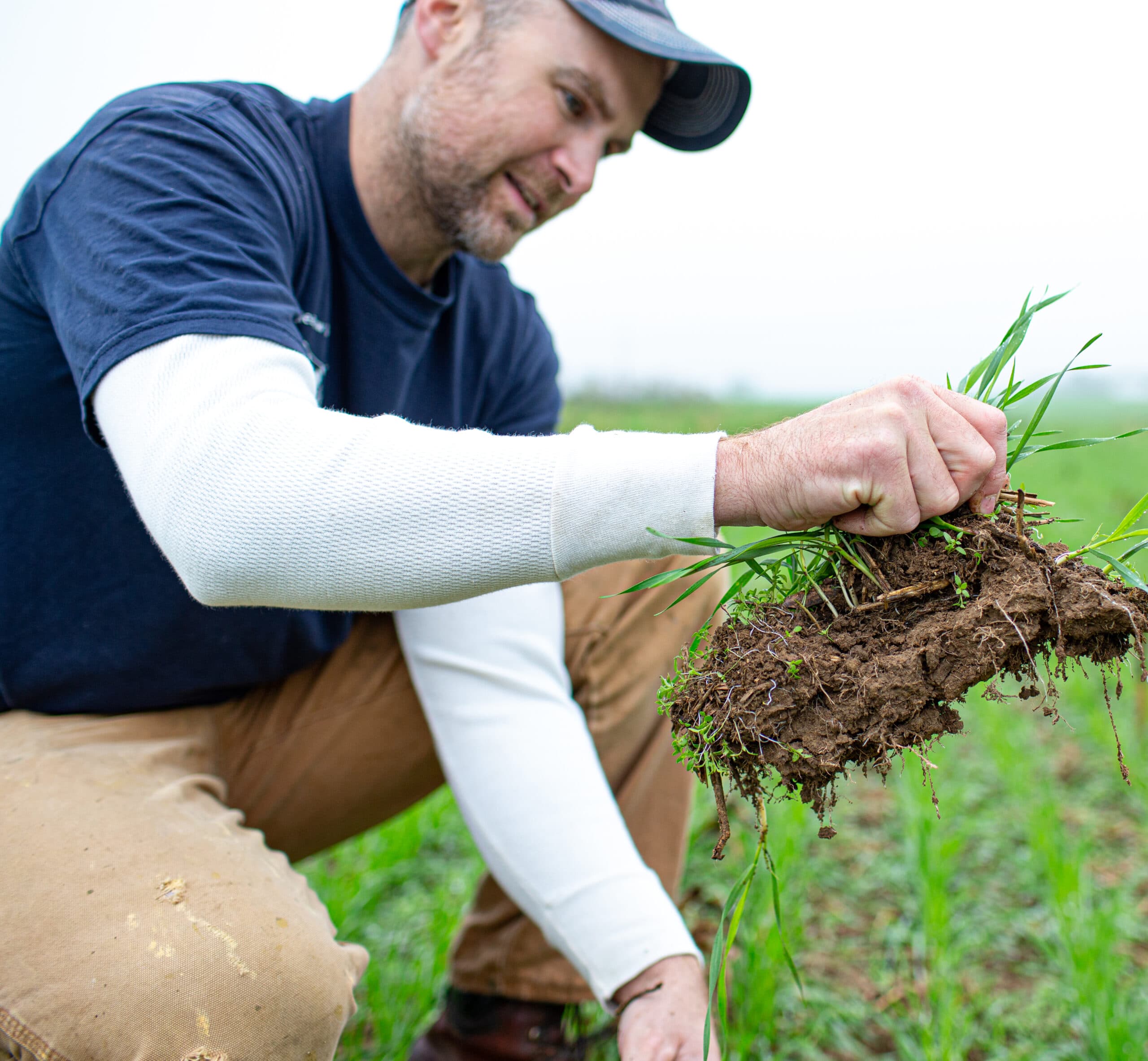 Farmer pulling up a mound of grass