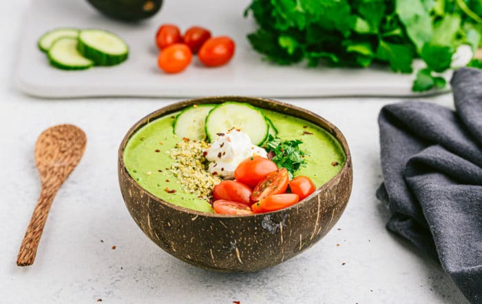 colorful smoothie bowl on a white counter with a wooden spoon