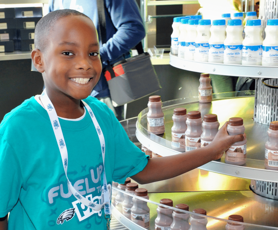 Kid smiling while grabbing a milk carton